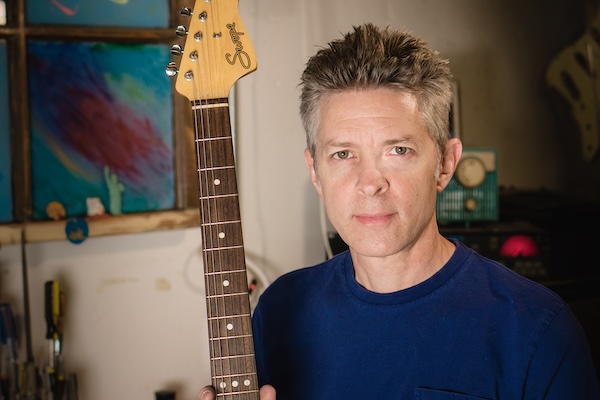 Portrait of Chris holding a guitar